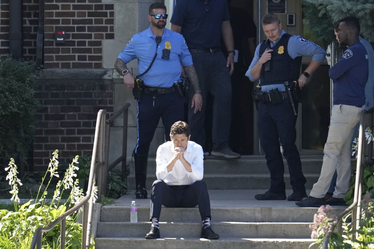 Minneapolis Mayor Jacob Frey sits on steps of the Annunciation Church's school as police response to a reported mass shooting, Wednesday, Aug. 27, 2025, in Minneapolis.