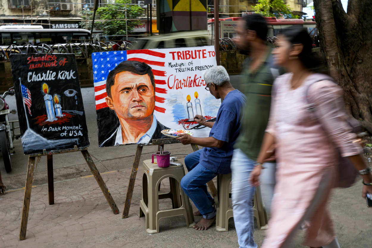 Artist works on a painting on Charlie Kirk.