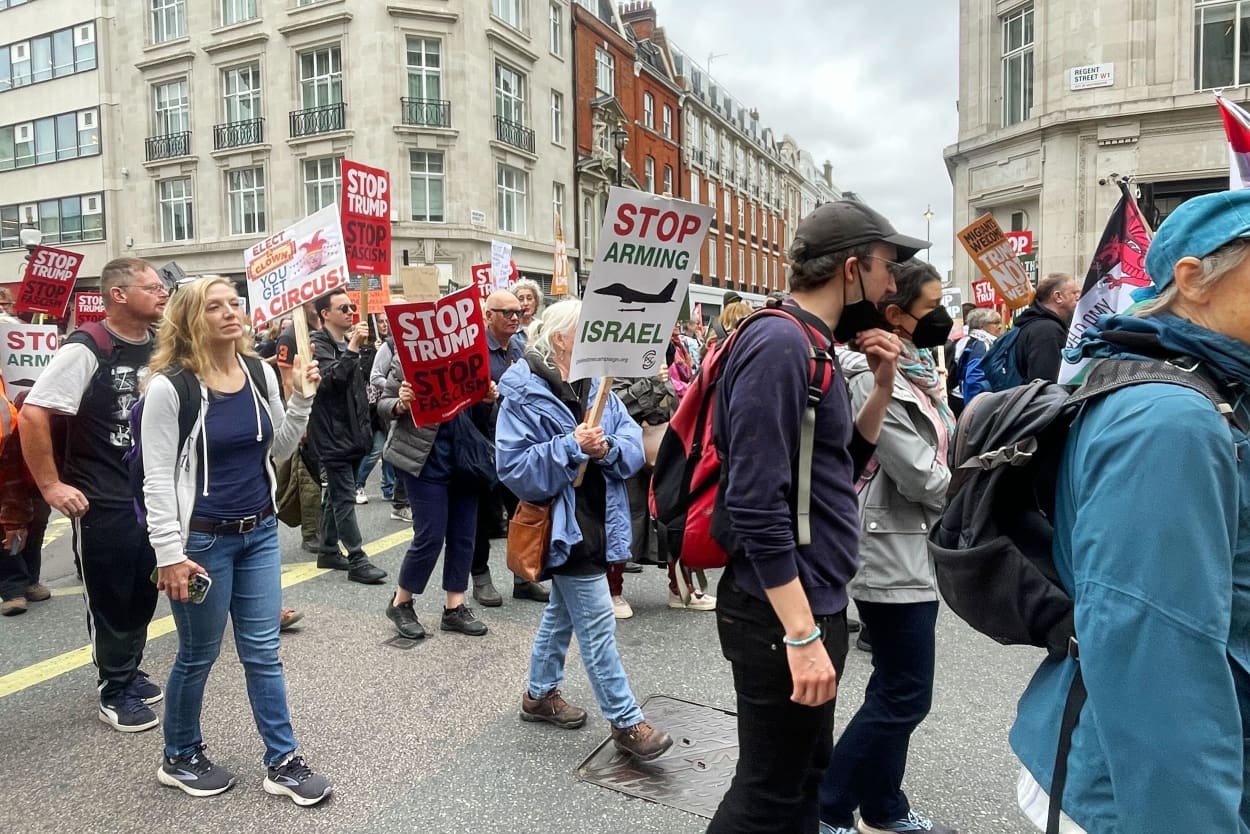 In a sea of anti-Trump protest signs, Palestinian flags and posters emblazoned with the words “end the genocide” also abound at the march in London rallying against the president’s state visit.