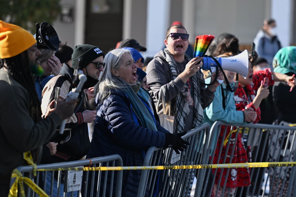People protest as law enforcement officers attend to the scene of the shooting involving federal law enforcement agents, Wednesday, Jan. 7, 2026, in Minneapolis. 