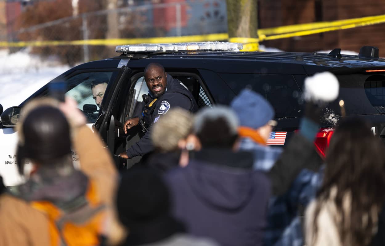 A Minneapolis Police officer reacts as their vehicle is hit by snowballs as they leave the scene after a shooting by an ICE agent during federal law enforcement operations on January 7, 2026 in Minneapolis.