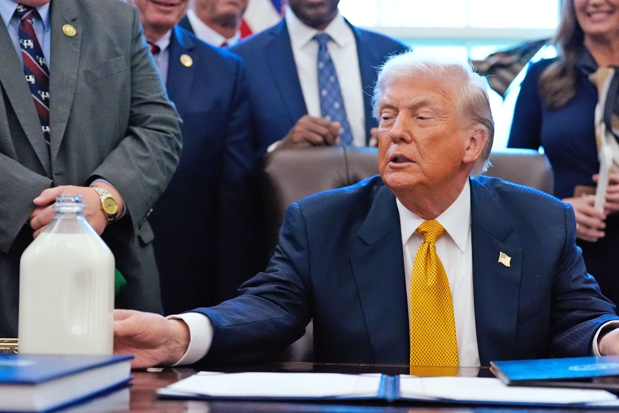 President Donald Trump touches a container of milk as he speaks in the Oval Office of the White House, Wednesday, Jan. 14, 2026.