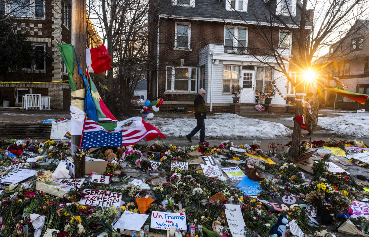A man visits a makeshift memorial for Renee Good on Jan. 14, 2026, at the site where she was killed a week ago in Minneapolis.