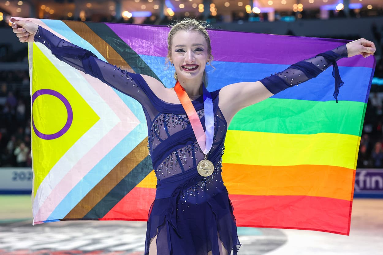 Image: Amber Glenn poses for a photo with a LGBTQIA+ flag during the Victory Ceremony 