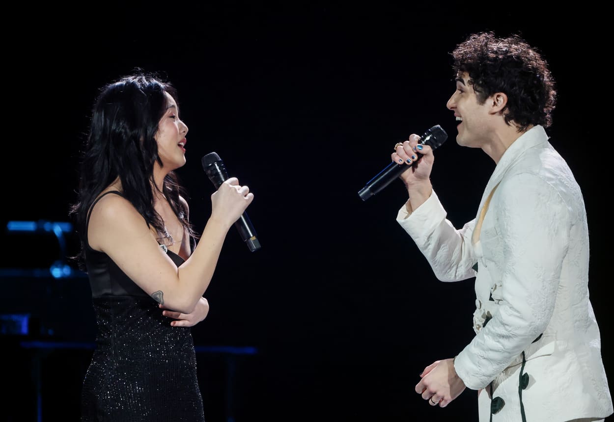 Helen J Shen and Darren Criss sing toward each other while performing onstage.
