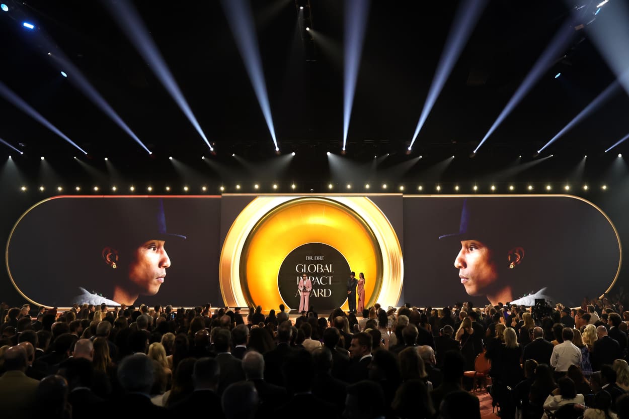 A wide view of the Grammy stage with Pharrell Williams' face projected onto the stage backdrop. 