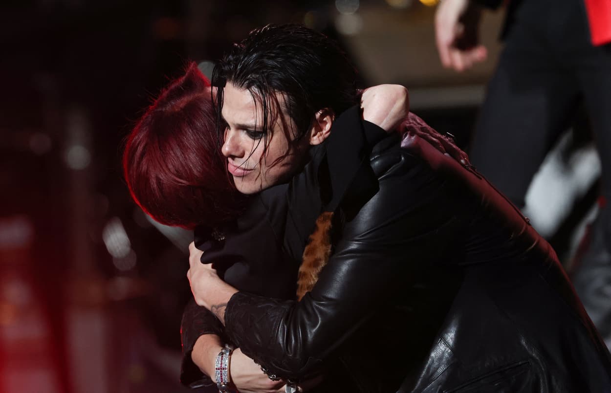 YUNGBLUD hugs Sharon Osbourne on stage. They both are wearing black.