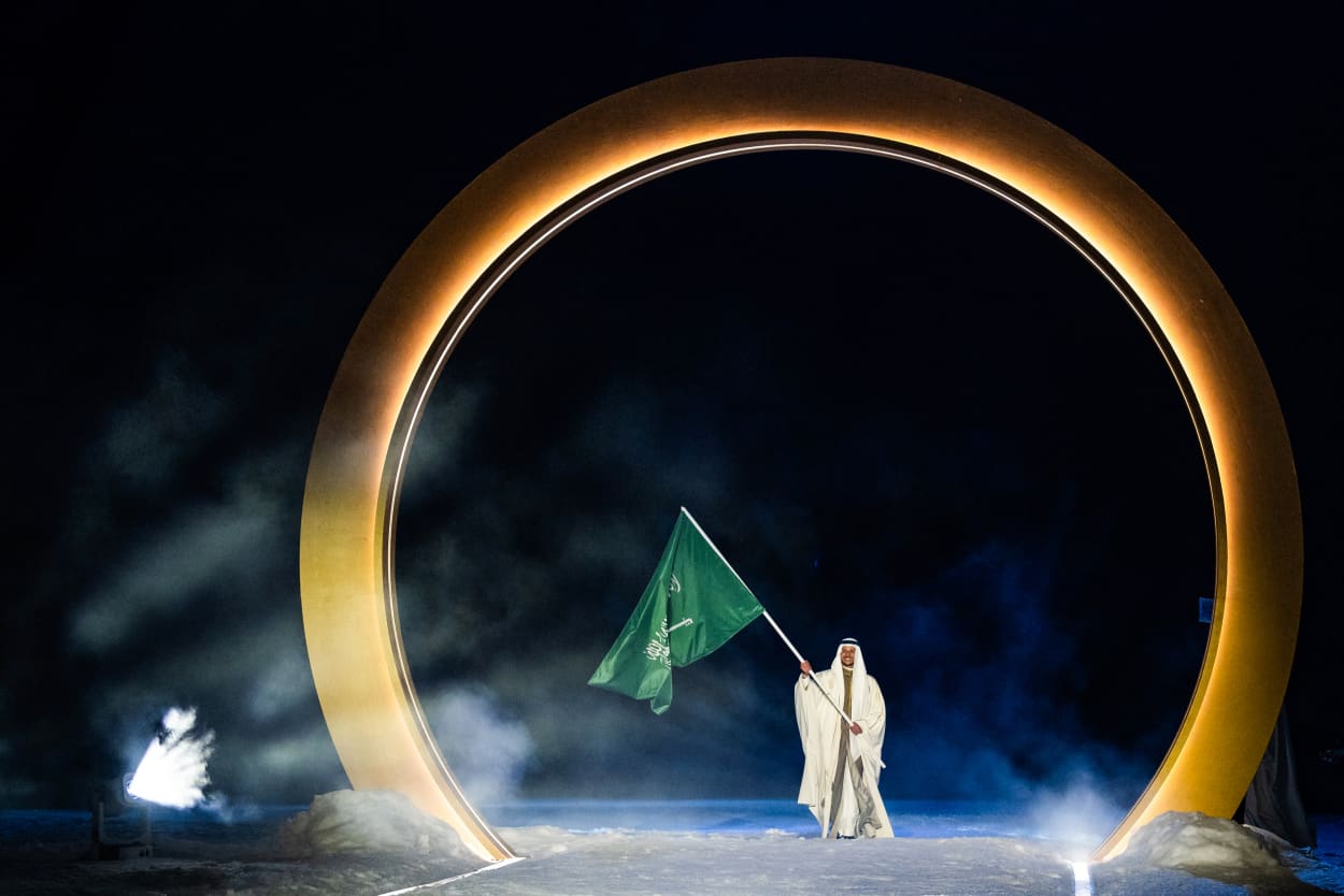 An athlete of team Saudi Arabia enters the stadium while holding a flag of his nation. 