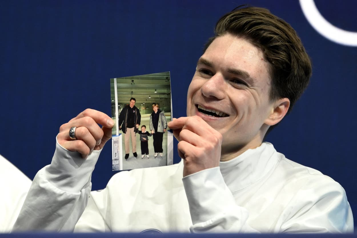 USA's Maxim Naumov holds a picture of his parents