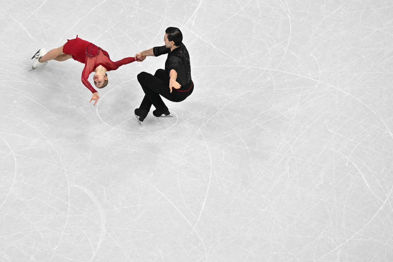 Two figure skaters are seen on the ice from an elevated perpspective.