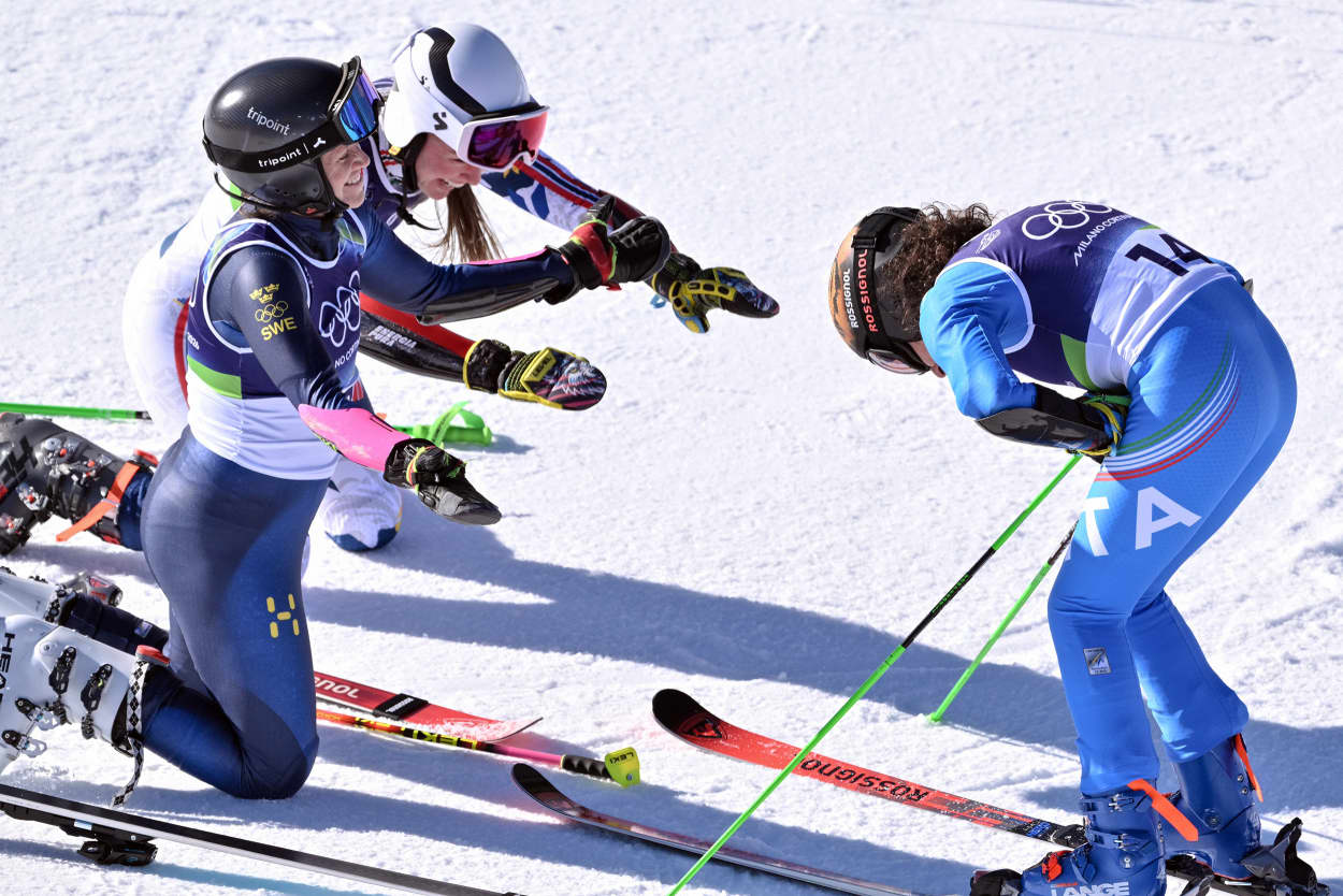 Norway's Thea Louise Stjernesund and Sweden's Sara Hector bow in front of Italy's Federica Brignone after she wins the women's giant slalom in Cortina d'Ampezzo on Feb. 15, 2026. 