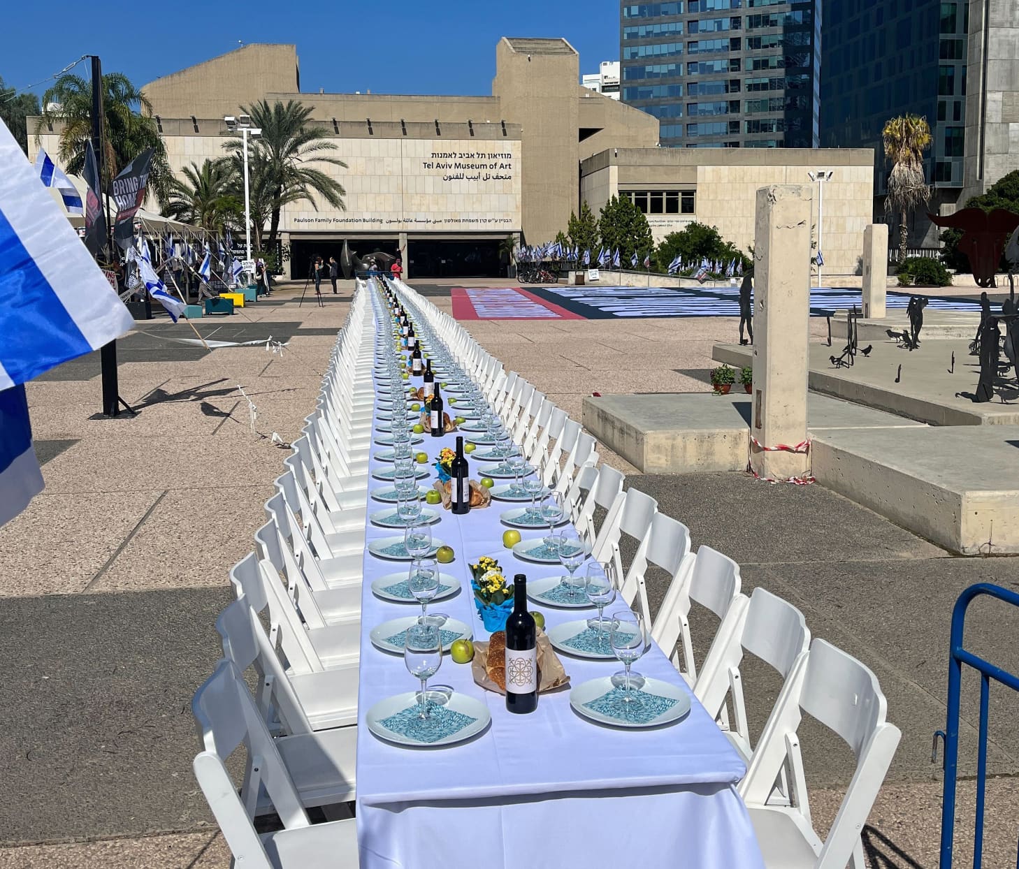 A "Shabbat Dinner" table with 200 empty seats representing hostages and missing people at the Tel Aviv Museum of Art.