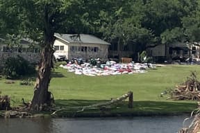 Children's belongings piled up outside buildings at Camp Mystic.