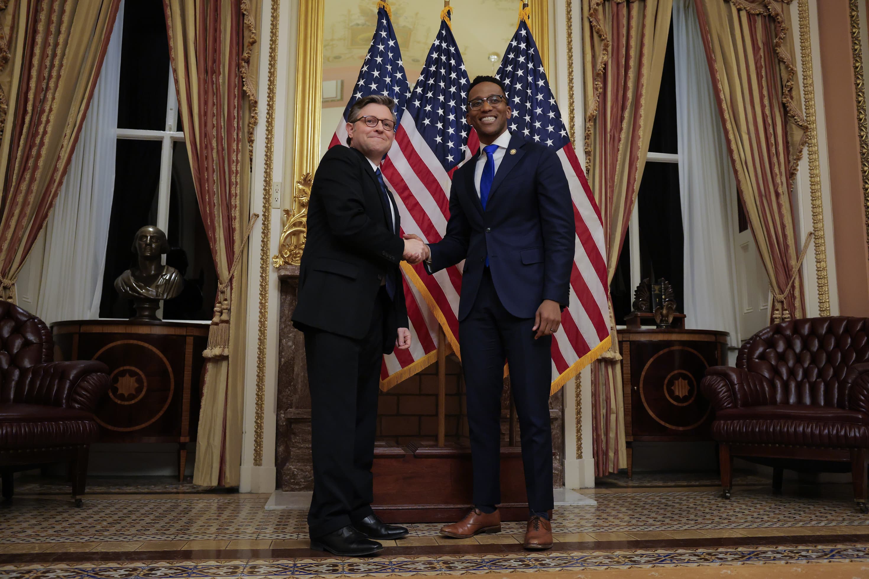 Left U.S. Speaker of the House Mike Johnson swears in Rep. Christian Menefee 