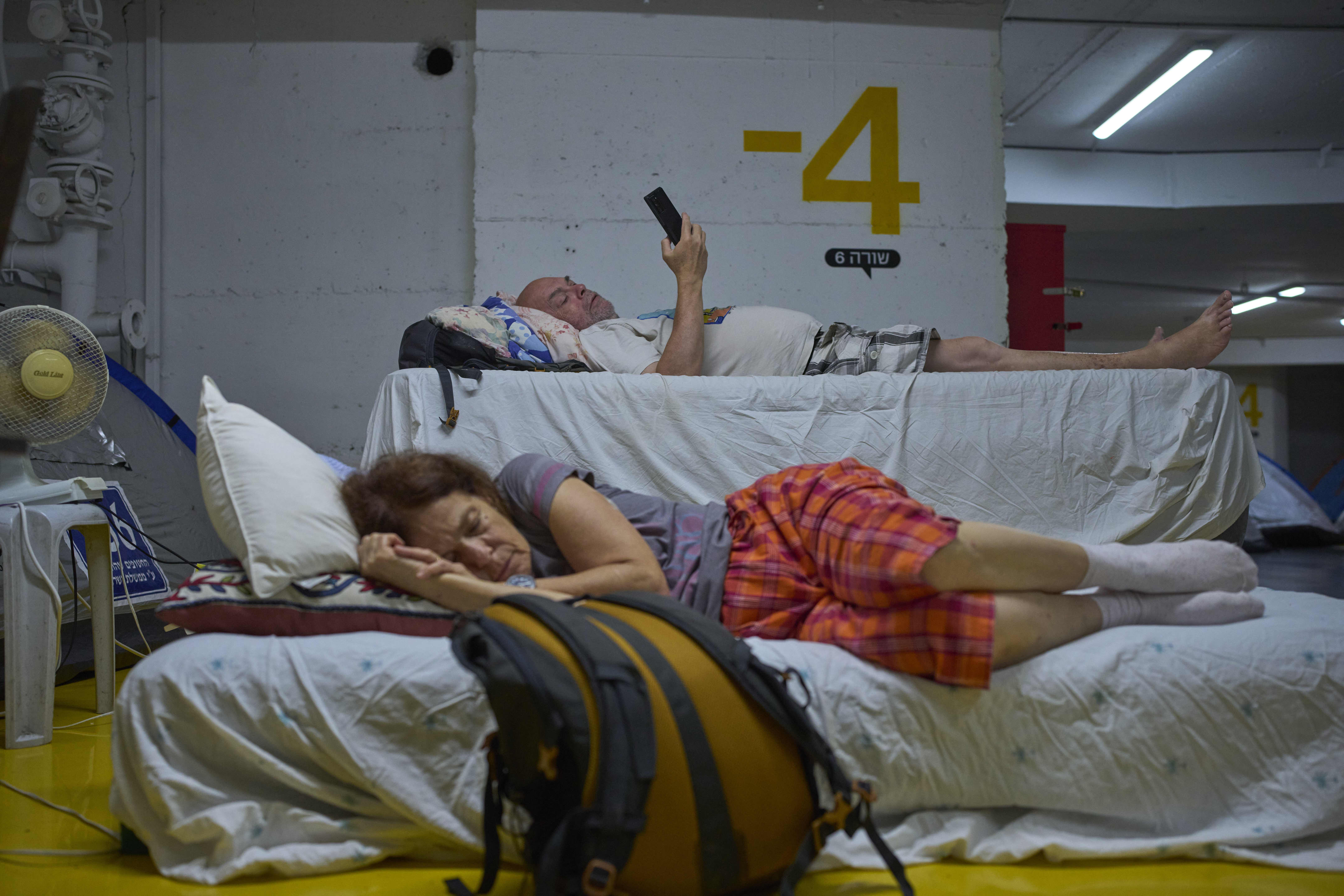 Algunos israelíes se refugiaron en un estacionamiento subterráneo en Tel Aviv, ante posibles ataques con misiles iraníes el 23 de junio.