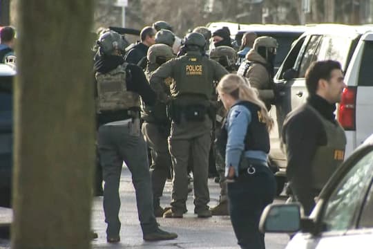 Police officers and federal agents on the scene outside standing on the street