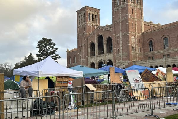 A demonstrator sits in front of barricades set up to protect an encampment on the UCLA campus on Wednesday, May 1, 2024, in Los Angeles. 