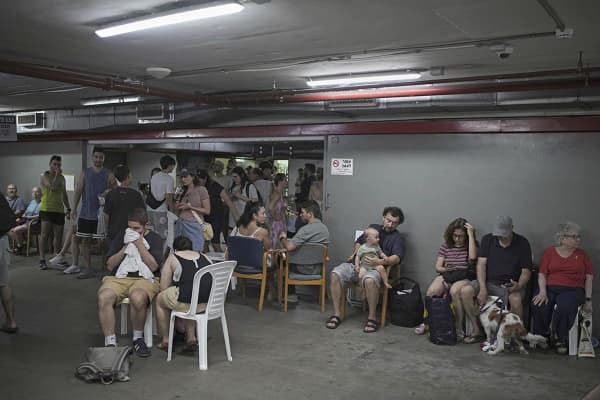 People take shelter as air raid sirens warn of incoming Iranian strikes in Tel Aviv, Israel, Friday, June 20, 2025.