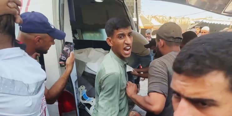 A man reacts as an ambulance arrives carrying the dead and wounded in Gaza