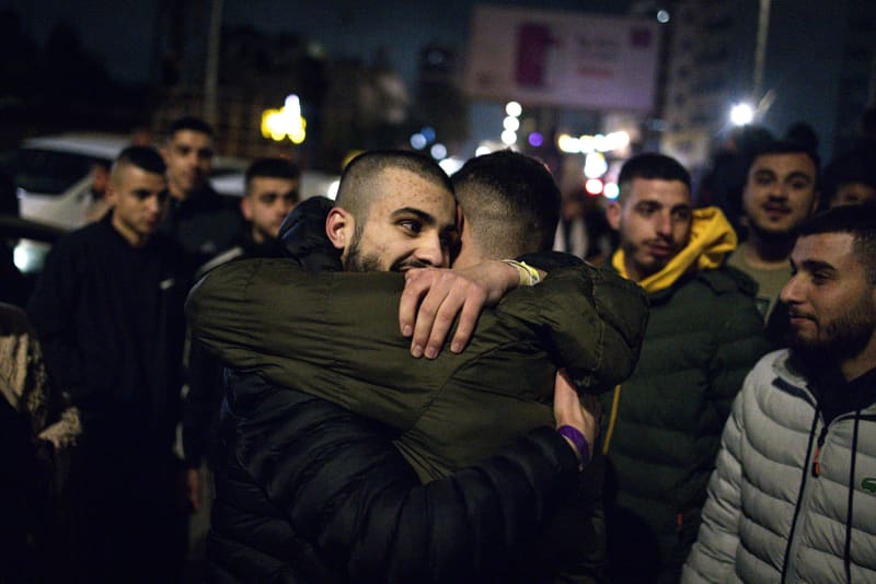 People embrace in a crowd outside