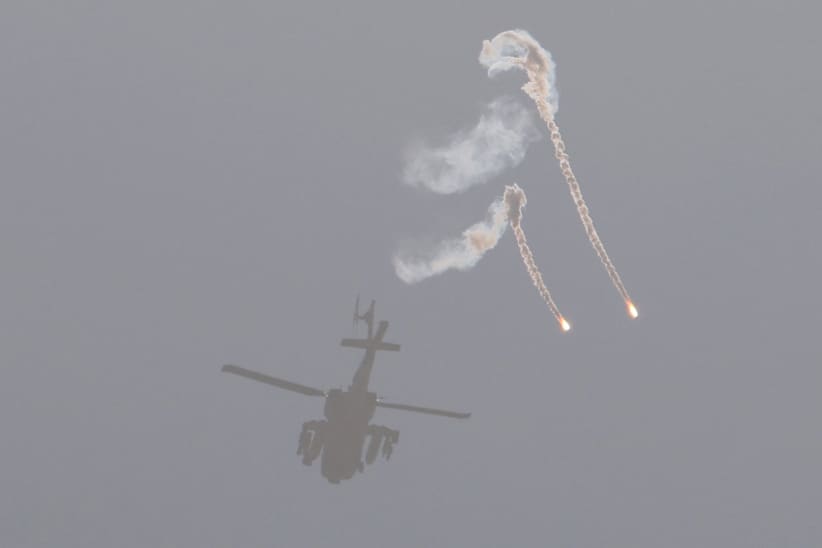 An Israeli air force attack helicopter releases flares while flying over the border with the Gaza Strip on Dec. 1, 2023.
