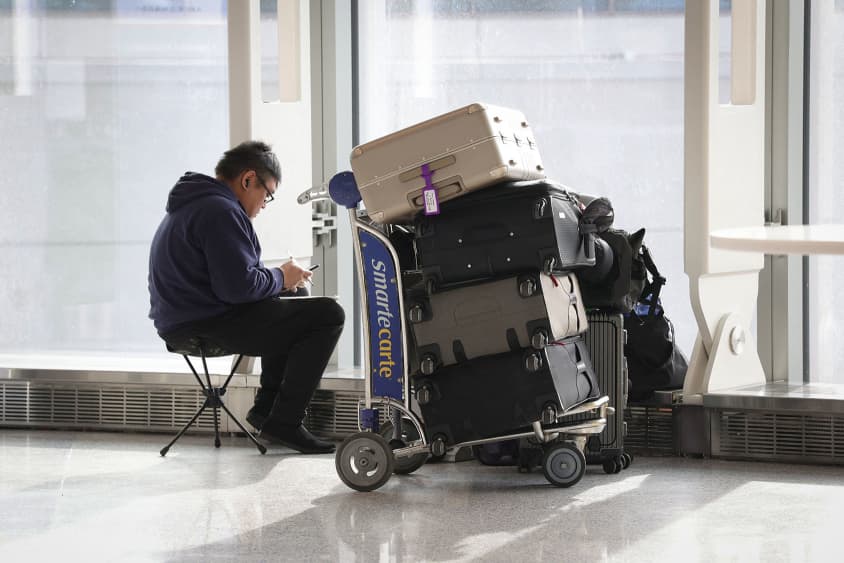 A traveler waits with his luggage at Newark Liberty International Airport in Newark, New Jersey, on Nov. 7, 2025.
