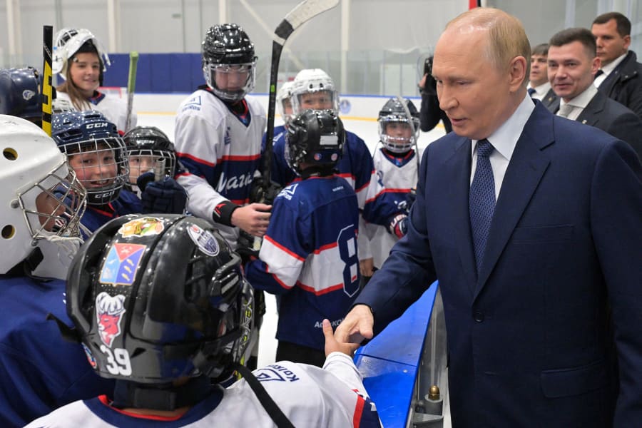 Russia's President Vladimir Putin shakes hands with a hockey player as he visits a sports complex in the far eastern port city of Magadan on the Sea of Okhotsk on Aug. 15, 2025.