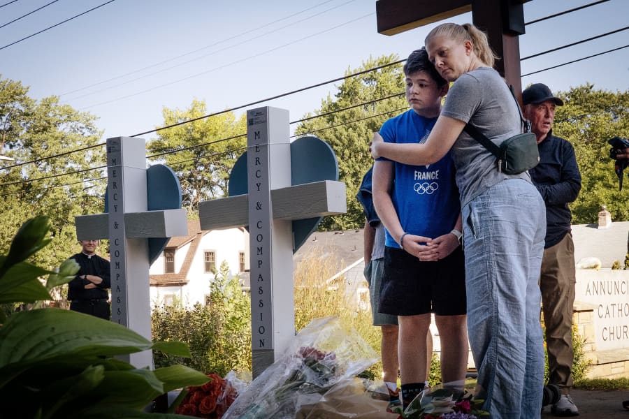 People visit a memorial to shooting victims in front of Annunciation Catholic Church on Aug. 28, 2025 in Minneapolis.