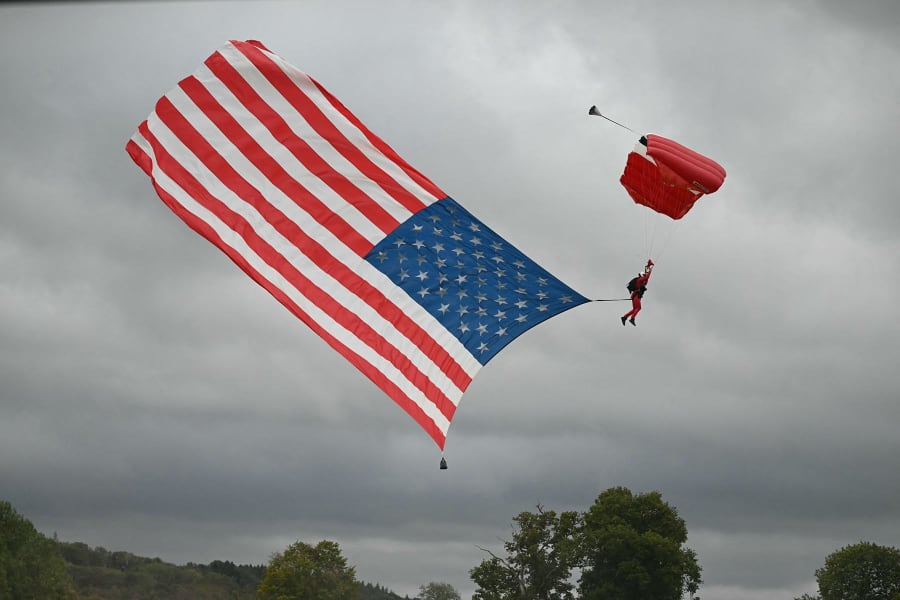 Members of the Red Devils parachute team fly a huge U.S. flag 