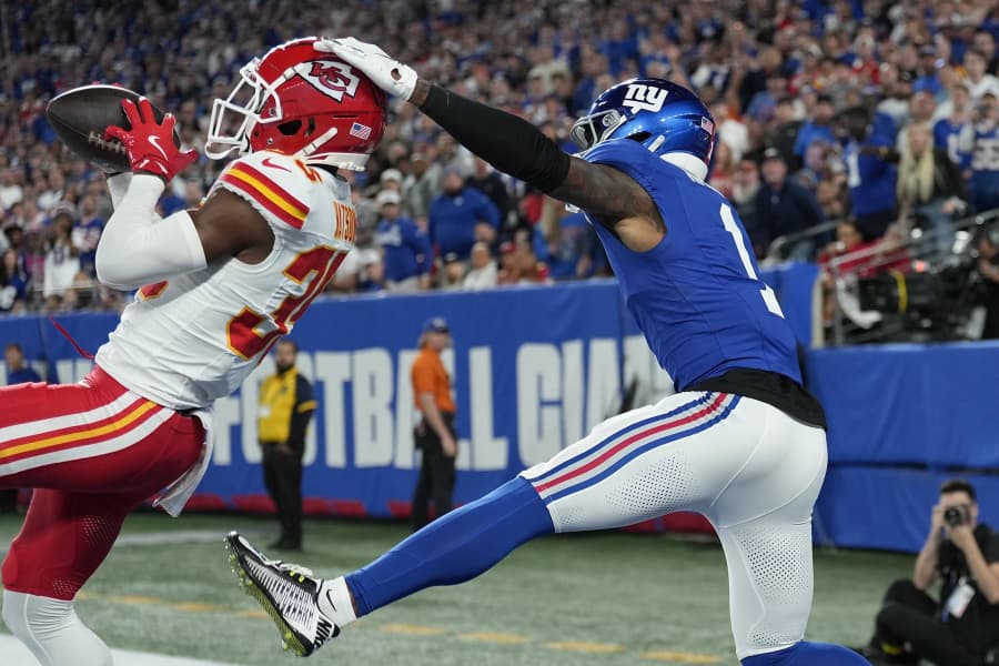 Kansas City Chiefs cornerback Jaylen Watson, left, intercepts a pass intended for New York Giants wide receiver Malik Nabers.