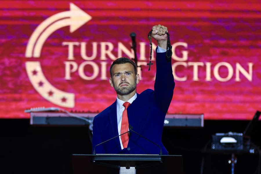 Political commentator Jack Posobiec holds up a cross as he speaks during the memorial service for political activist Charlie Kirk