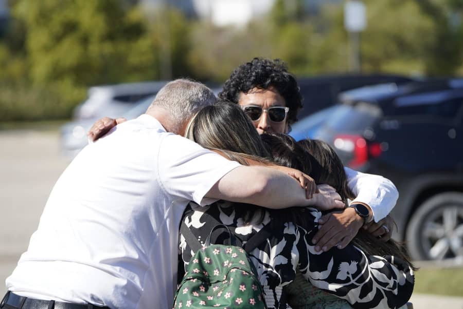 People meet at a reunification area at the Trillium Theater after an active shooter incident and fire at The Church of Jesus Christ of Latter-day Saints
