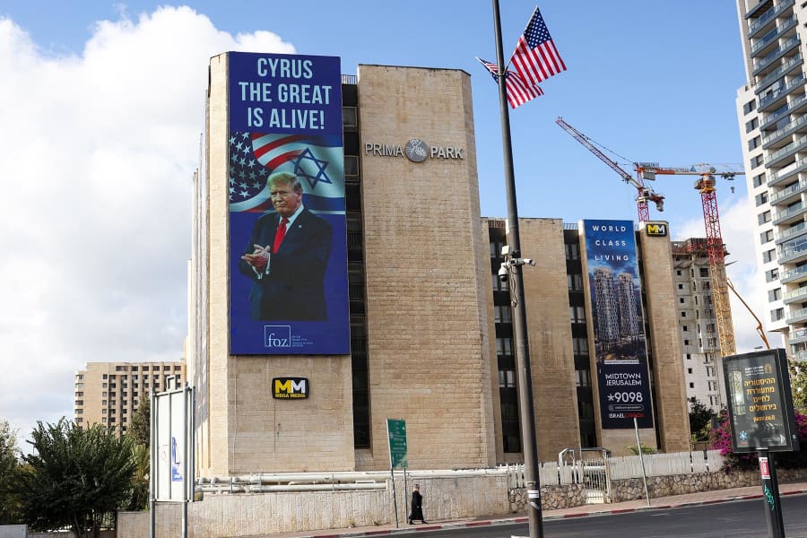 A woman walks past a billboard praising President Donald Trump in Jerusalem on October 10, 2025.