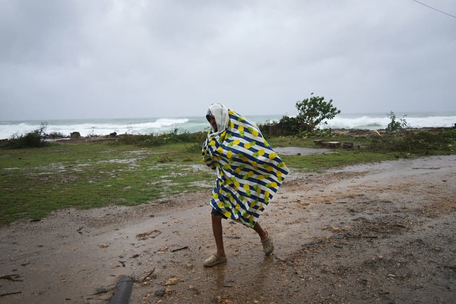 A man walks in the rain before the arrival of Hurricane Melissa in Santiago de Cuba, Tuesday, Oct. 28, 2025.