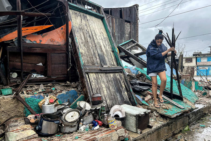A woman salvages belongings from the rubble of her home after it collapsed during Hurricane Melissa's passage through Santiago de Cuba, Cuba, on Oct. 29, 2025.