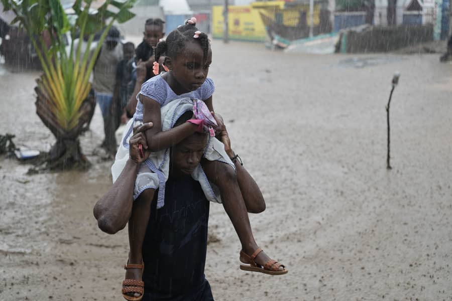 Residents wade through a flooded street in the aftermath of Hurricane Melissa in Petit-Goave, Haiti, Thursday, Oct. 30, 2025.