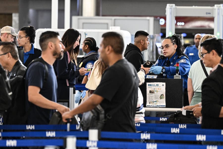 Travelers wait in line at a security checkpoint
