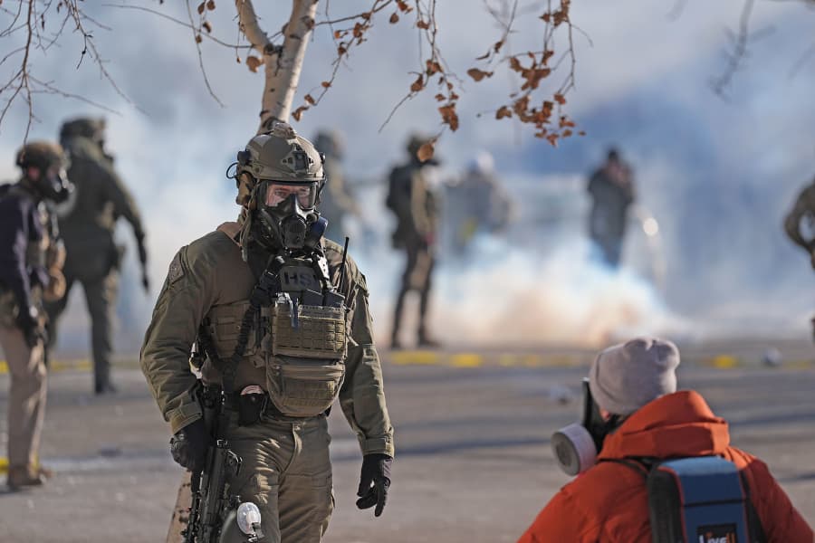 Federal immigration officers deploy tear gas after a shooting Saturday, Jan. 24, 2026, in Minneapolis. 