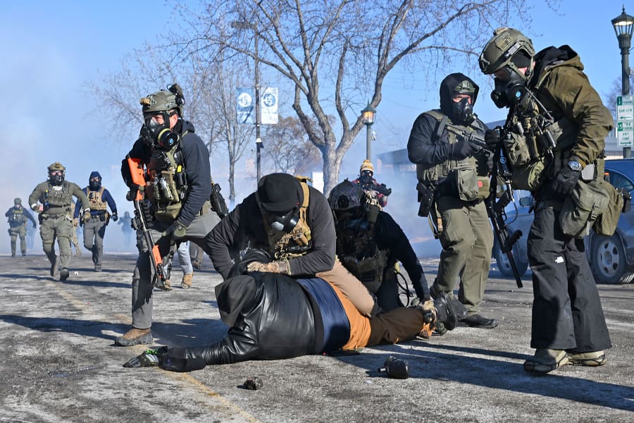 A person is tackled by a federal agent amid protests following a shooting on January 24, 2026 in Minneapolis, Minnesota. 