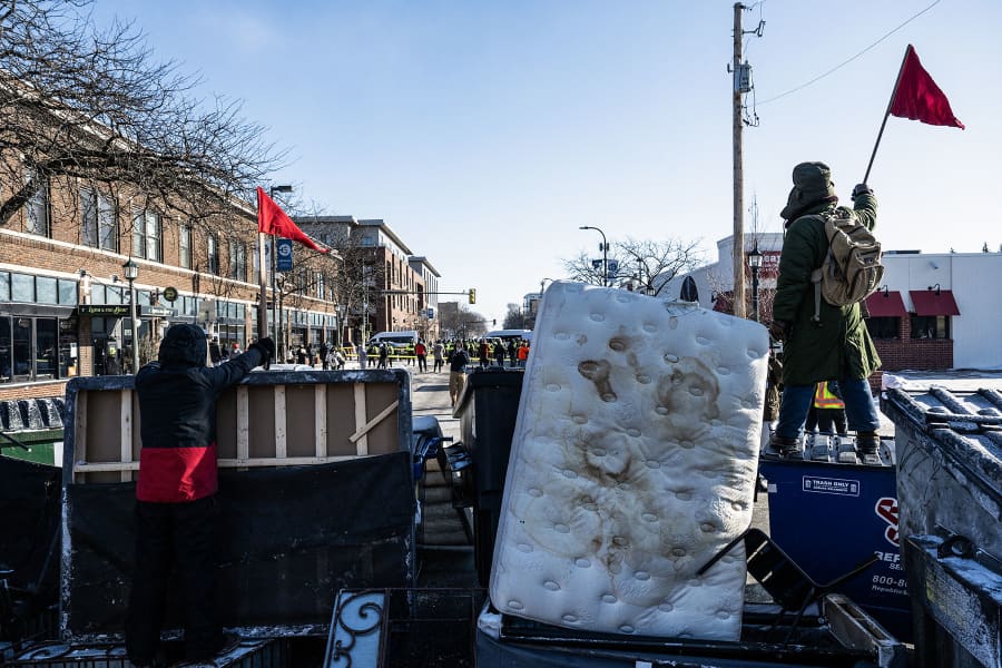 Demonstrators gather behind a barricade near the site of where state and local authorities say a man was shot and killed by federal agents earlier in the morning in Minneapolis, Minnesota, on January 24, 2026. 