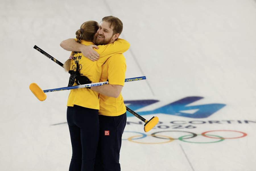 Sweden's Isabella Wranaa and  Rasmus Wrana celebrate at the end of the curling mixed doubles round robin semi-final between Great Britain and Sweden