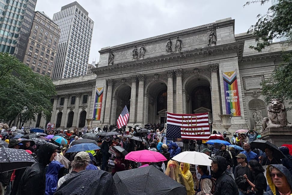Protesters gather on the steps of the New York City Public Library, braving the rain to demonstrate against today’s military parade in Washington.