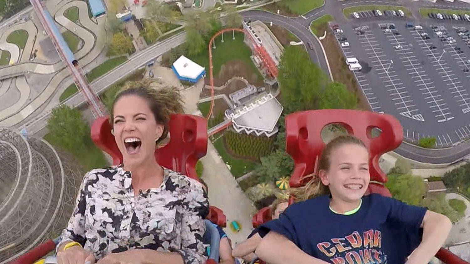 Jenna kicks back while Natalie soars, screams on giant roller coaster ride.