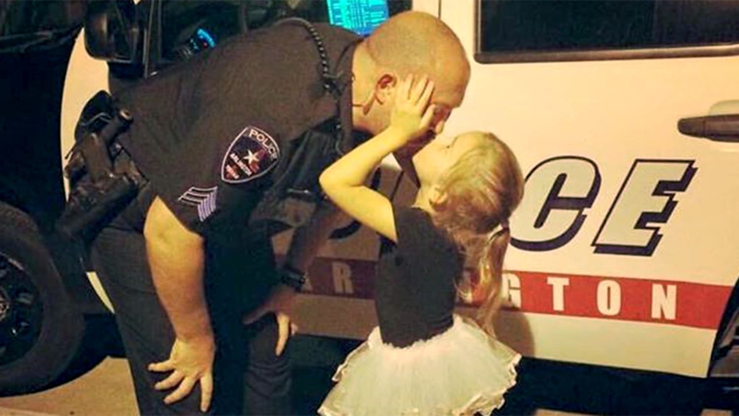 Arlington Police Department/FacebookPoliceman dad kisses ballerina daughter