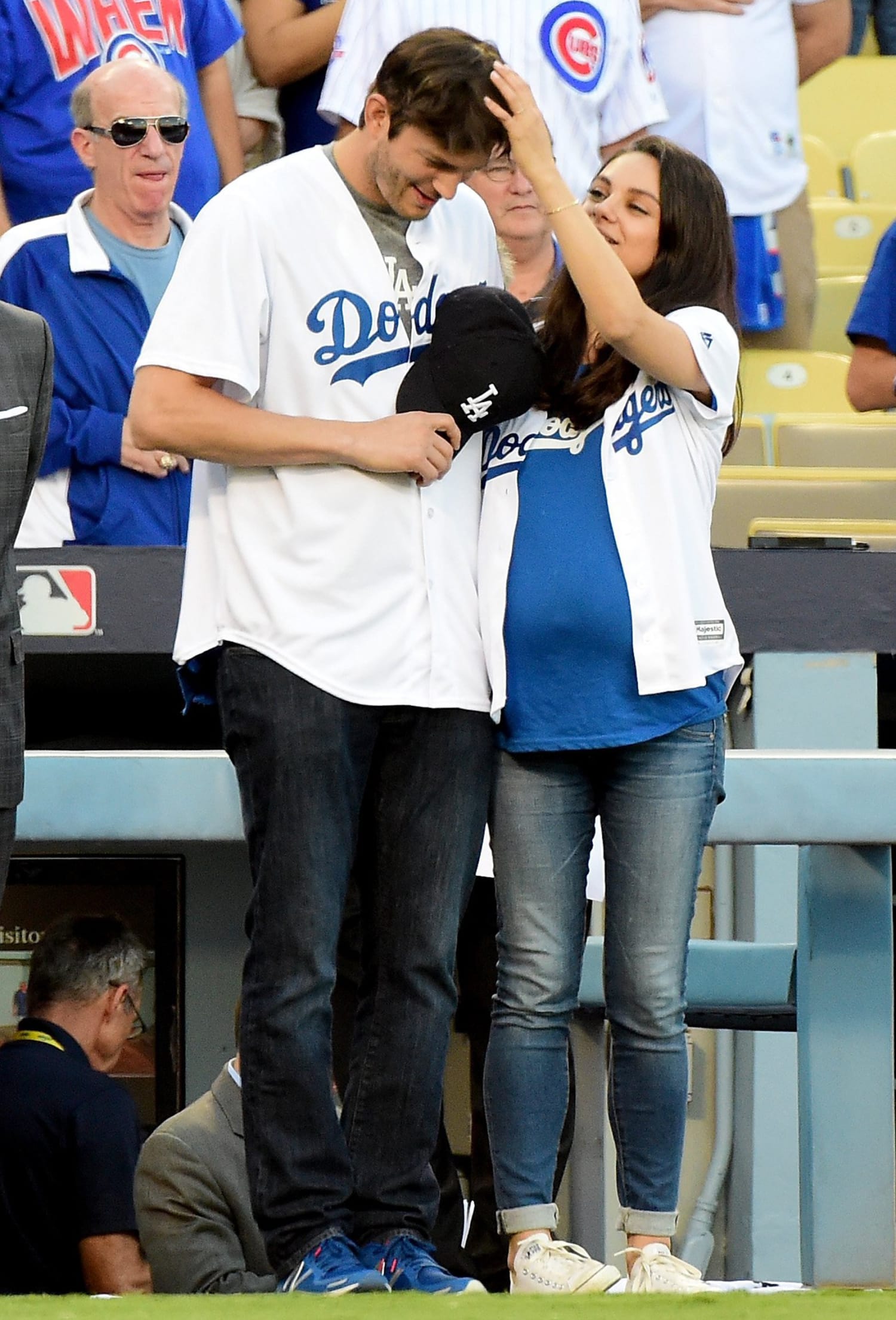 Pregnant Mila Kunis and hubby Ashton Kutcher put on PDA in matching outfits  at LA Dodgers crucial playoff game