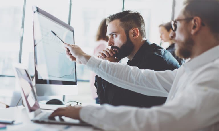 two male employees working at computer