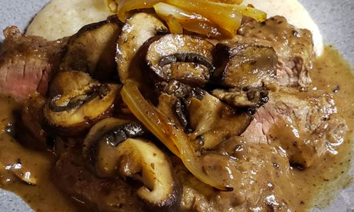 Smothered Steak and Mushrooms Over Creamy Grits Recipe-image