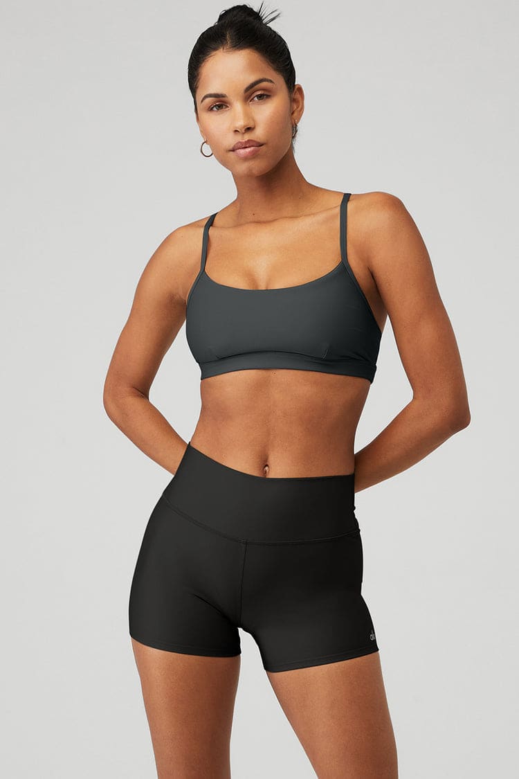 Fit pretty black girl in sports bra and shorts running down a