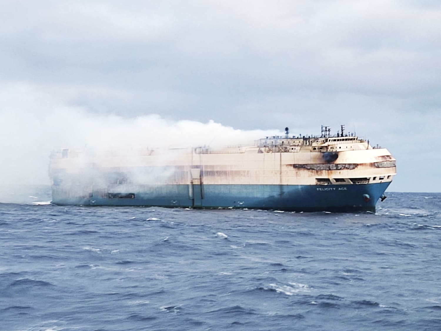 Tugboats spray water on burning ship carrying Porsches, Audis and Bentleys