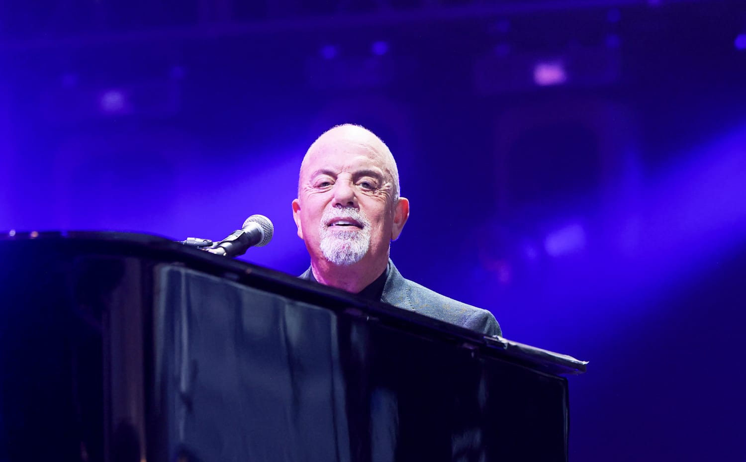 Billy Joel looks at a banner at a press conference where he is